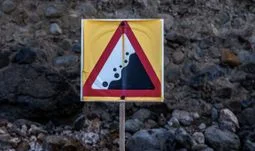 A cliff edge sign against a cliff