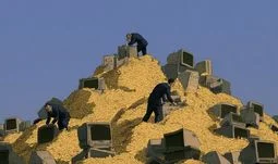 bankers sifting through gold coins and old computers 