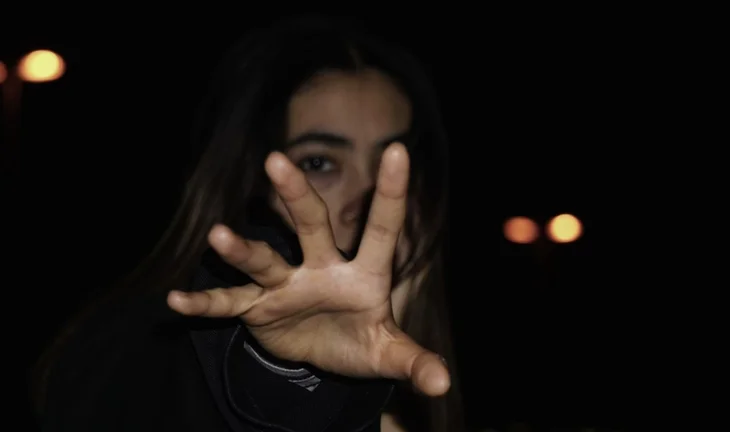 a woman with her hand out in the dark