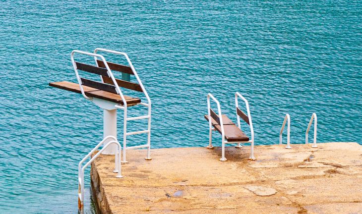 some diving boards, blue sea, beige podium