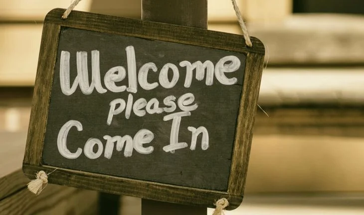 a sign that says welcome please come in